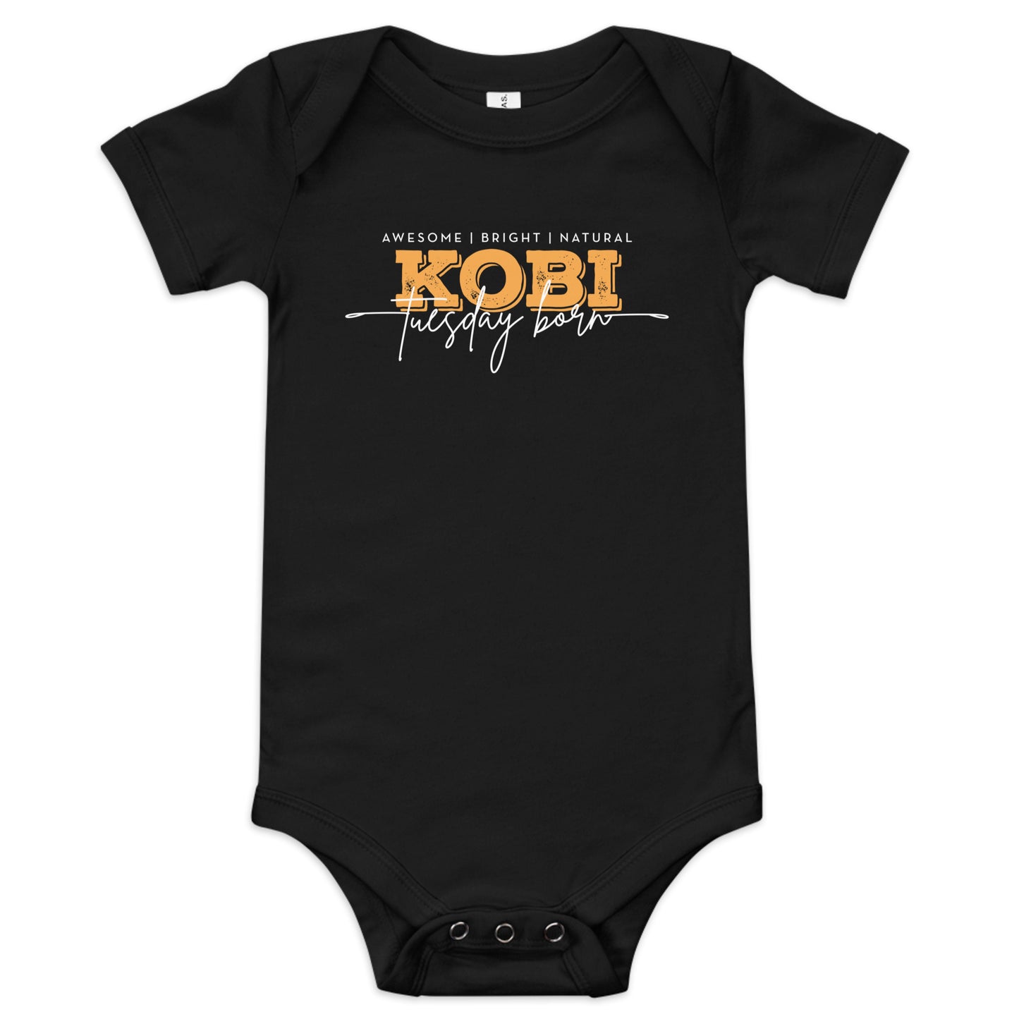 A white short-sleeve baby bodysuit with a graphic print on the chest reading 'AWESOME | BRIGHT | NATURAL KOBI tuesday born' in white and yellow lettering, shown on a plain white background